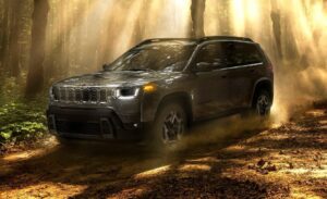 2026 Jeep Cherokee parked on a rugged trail with mountains in the background